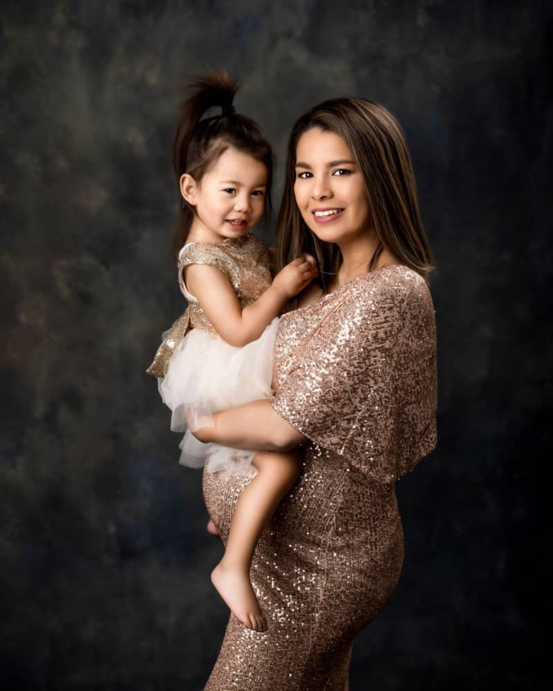 Family Maternity Photoshoot of a pregnant mother in a gold sequenced gown with her daughter